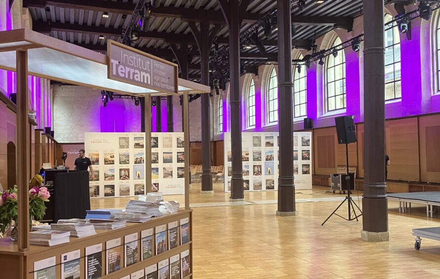 Exposition professionnelle, avec stand d’accueil, panneaux d’exposition et mise en lumière événementielle violette.